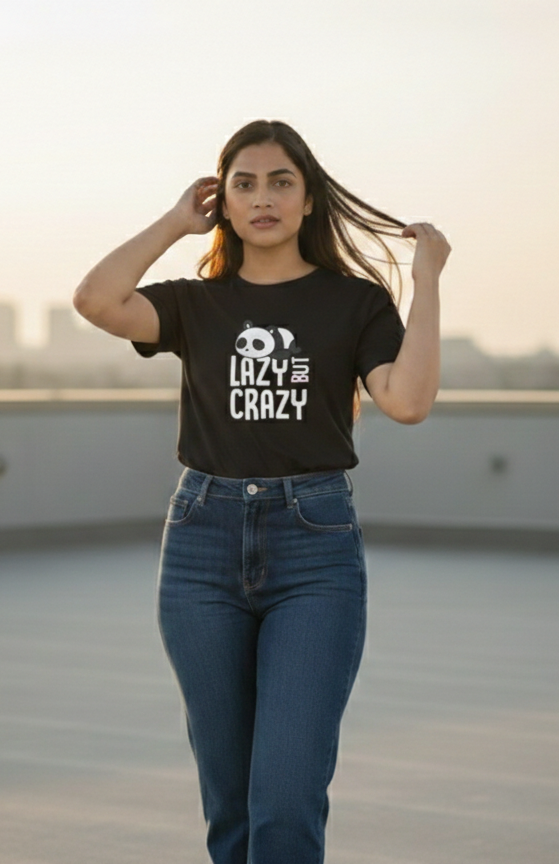 Woman wearing a black t-shirt with text and blue jeans on a rooftop with cityscape in the background