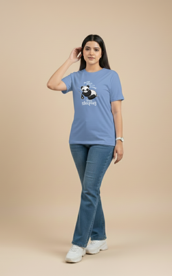 Woman wearing a blue t-shirt with a panda graphic and text on a beige background